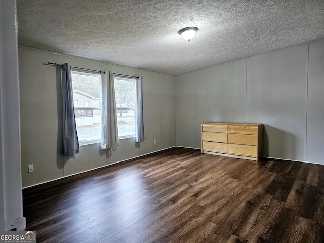 unfurnished bedroom featuring a textured ceiling and dark hardwood / wood-style flooring