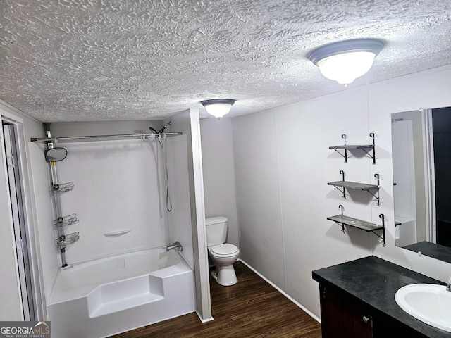 full bathroom featuring hardwood / wood-style flooring, toilet, shower / bathing tub combination, and a textured ceiling