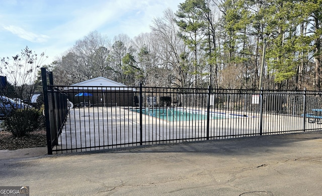 view of gate with a community pool and a patio area