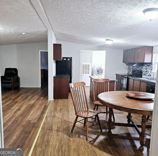 dining room featuring washer / clothes dryer, dark hardwood / wood-style floors, sink, and a textured ceiling