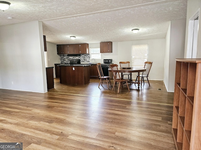 dining room featuring sink, dark wood-type flooring, and a textured ceiling