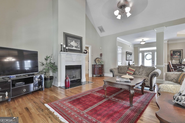 living room with crown molding, ceiling fan, decorative columns, and hardwood / wood-style floors