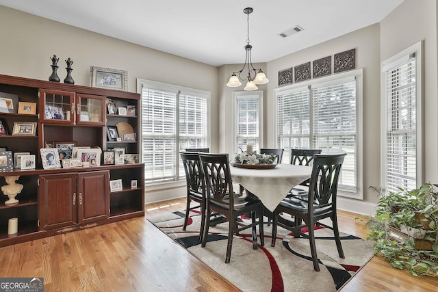 dining area with a chandelier and light hardwood / wood-style flooring