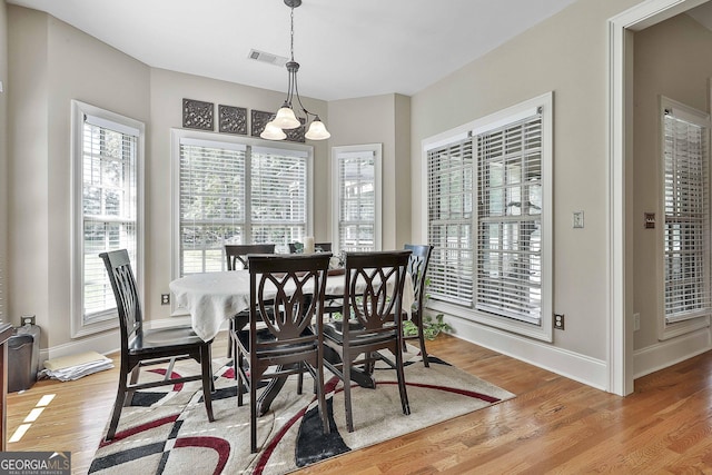 dining area featuring light hardwood / wood-style floors, a chandelier, and a healthy amount of sunlight