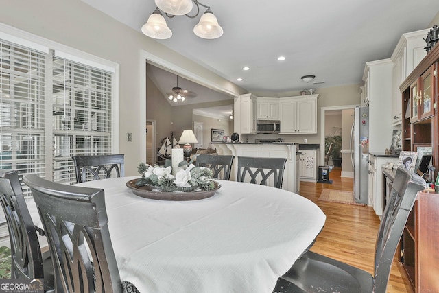 dining area featuring light hardwood / wood-style flooring and vaulted ceiling