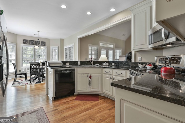 kitchen featuring white cabinetry, appliances with stainless steel finishes, decorative light fixtures, and kitchen peninsula