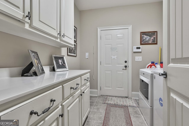 laundry area with light tile patterned flooring, cabinets, and washer and clothes dryer