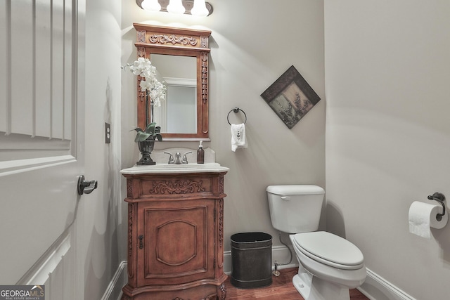 bathroom featuring vanity, hardwood / wood-style floors, and toilet