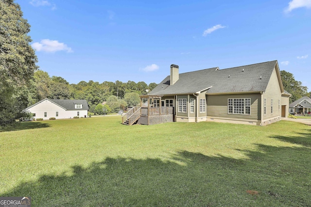 back of property with a wooden deck and a yard