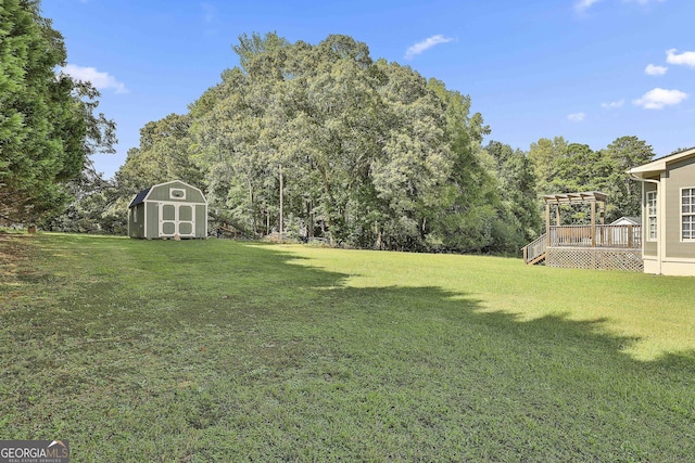 view of yard with a shed, a pergola, and a deck