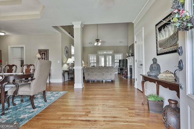 interior space with ornamental molding, decorative columns, and light wood-type flooring