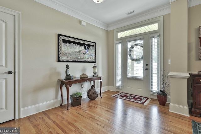 entrance foyer with crown molding and light hardwood / wood-style flooring