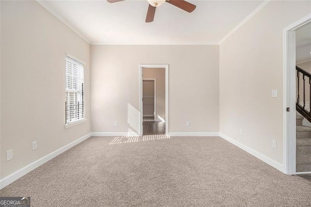 carpeted empty room with ornamental molding and ceiling fan