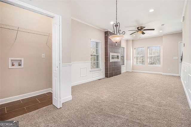 unfurnished living room featuring ornamental molding, carpet, a wealth of natural light, and a fireplace