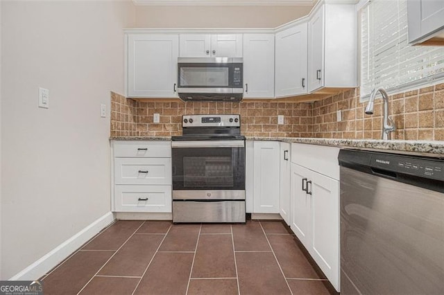 kitchen featuring stone counters, stainless steel appliances, tasteful backsplash, and white cabinets