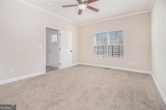 carpeted spare room featuring a wealth of natural light, ornamental molding, and ceiling fan