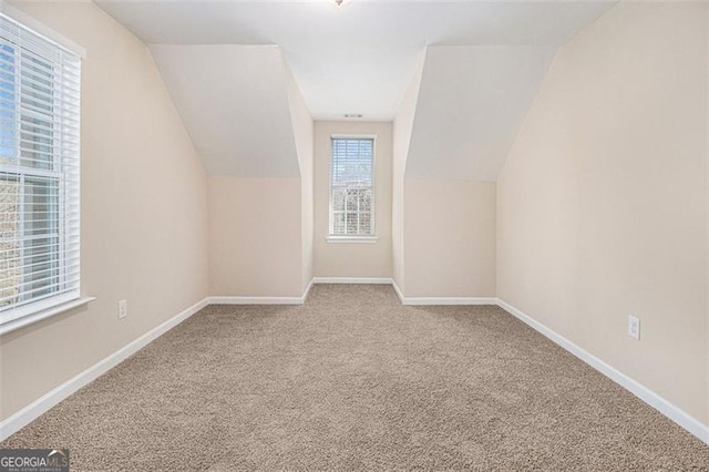 bonus room with vaulted ceiling and carpet