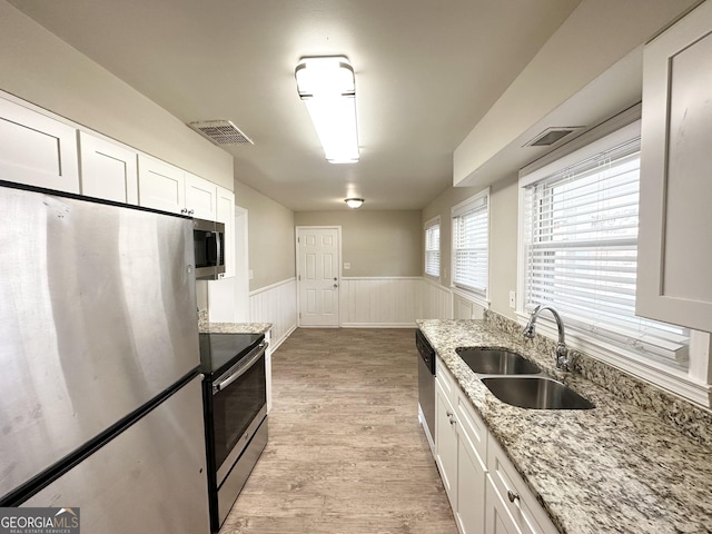 kitchen featuring appliances with stainless steel finishes, light stone countertops, and white cabinets