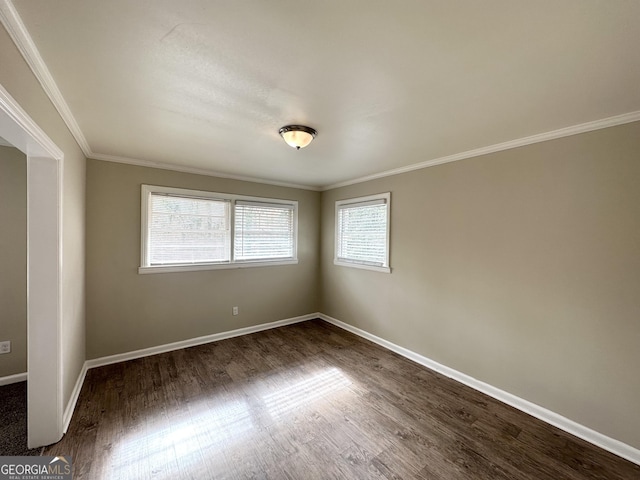 unfurnished room with ornamental molding and dark hardwood / wood-style floors