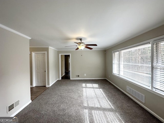 unfurnished room featuring ornamental molding, ceiling fan, and dark carpet