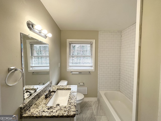 full bathroom featuring vanity, tiled shower / bath, toilet, and a healthy amount of sunlight