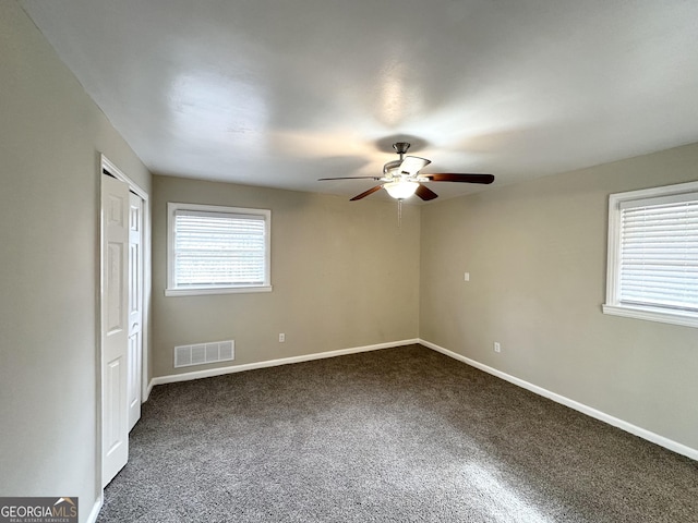 carpeted spare room with ceiling fan