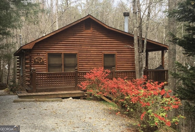 view of side of property featuring covered porch and log exterior