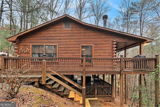 rear view of house with stairway, a deck, and log siding