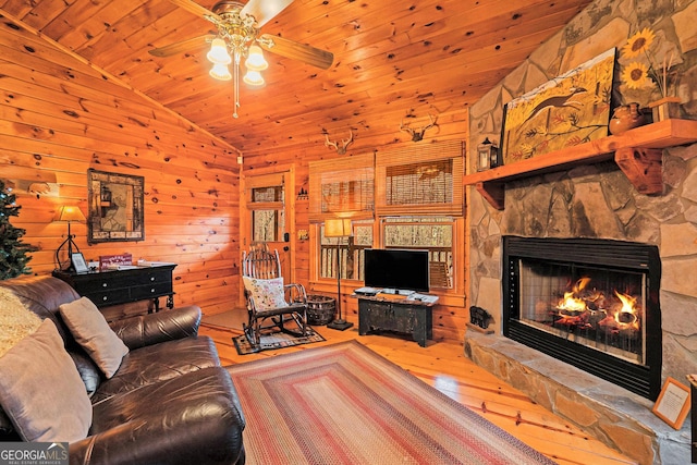 living area with lofted ceiling, hardwood / wood-style flooring, wooden walls, a fireplace, and wood ceiling