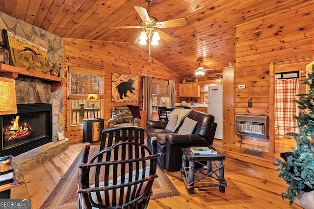 living room featuring wooden ceiling, wooden walls, a fireplace, light wood-style floors, and heating unit