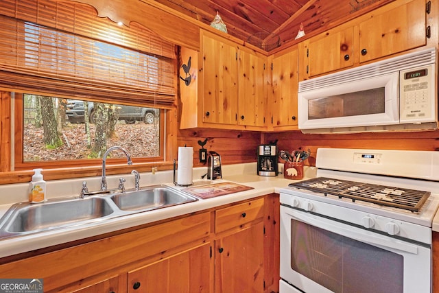 kitchen featuring lofted ceiling, light countertops, wooden ceiling, a sink, and white appliances