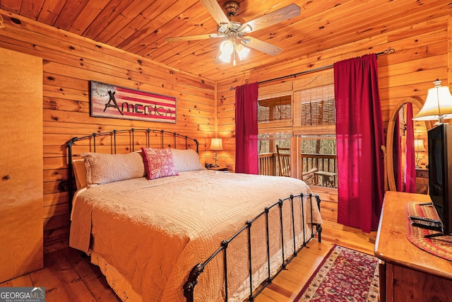 bedroom featuring wood ceiling, ceiling fan, hardwood / wood-style flooring, and wooden walls