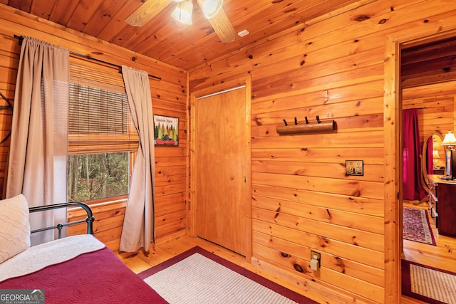 bedroom featuring wooden ceiling, wooden walls, and wood finished floors