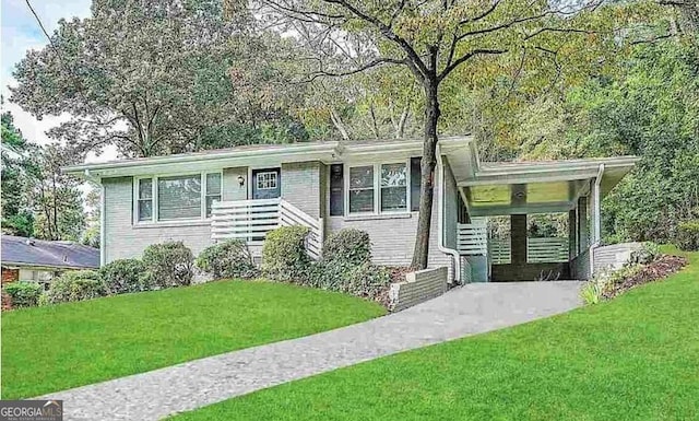 view of front of home with a carport and a front lawn