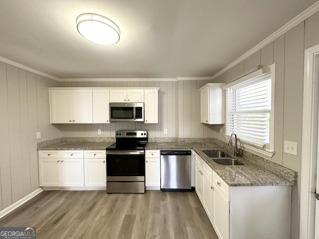 kitchen with sink, light hardwood / wood-style floors, white cabinets, and appliances with stainless steel finishes