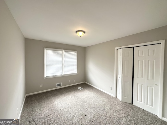 unfurnished bedroom featuring carpet flooring and a closet