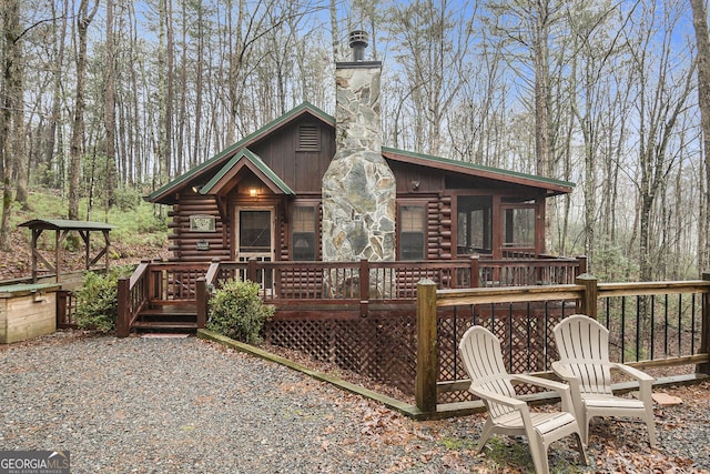 rear view of property with a wooden deck and a sunroom