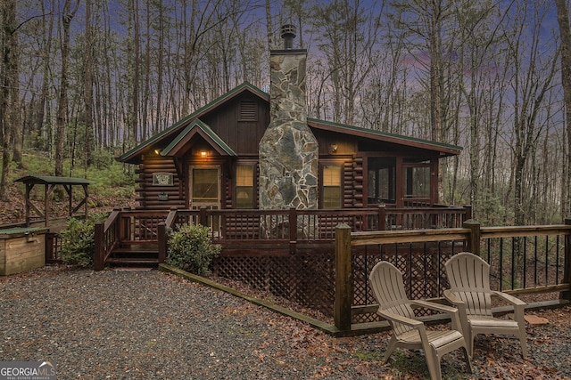 back house at dusk featuring a deck