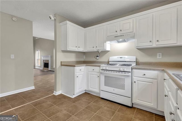 kitchen featuring white cabinetry, white gas range, tile patterned flooring, and a textured ceiling