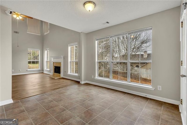 unfurnished living room with tile patterned flooring and a textured ceiling