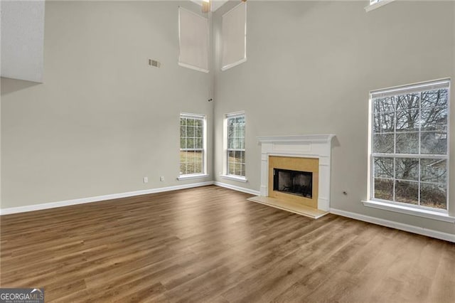 unfurnished living room with hardwood / wood-style floors and a high ceiling