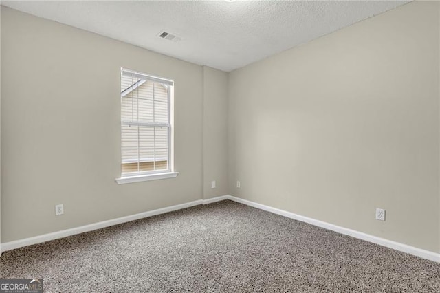 unfurnished room with a textured ceiling and carpet