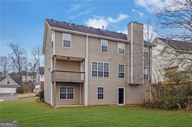 back of house with a balcony and a yard