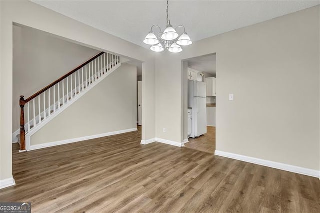 unfurnished dining area featuring hardwood / wood-style flooring and a notable chandelier