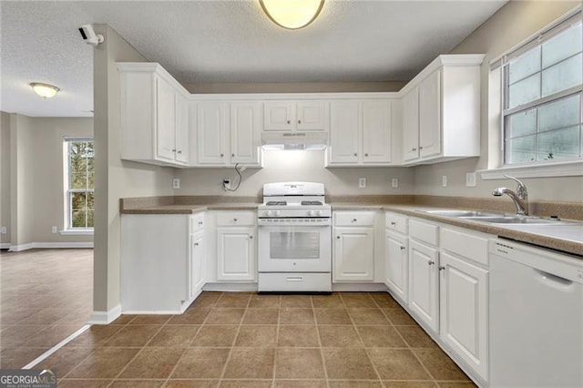 kitchen featuring sink, white appliances, white cabinetry, a textured ceiling, and light tile patterned flooring