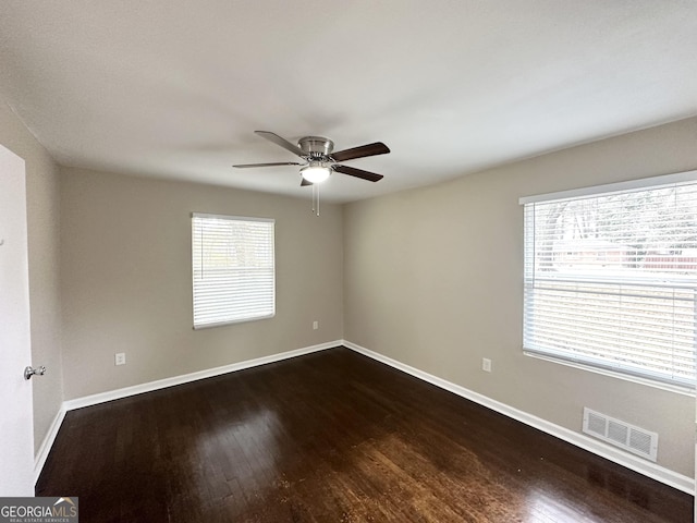 unfurnished room featuring dark wood-type flooring and ceiling fan