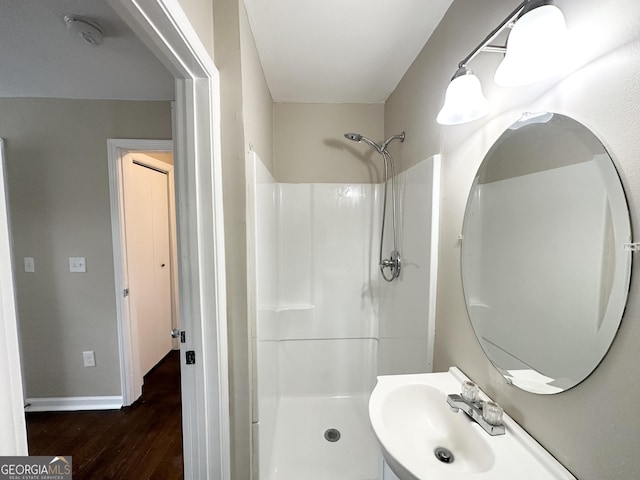 bathroom featuring sink, hardwood / wood-style floors, and a shower