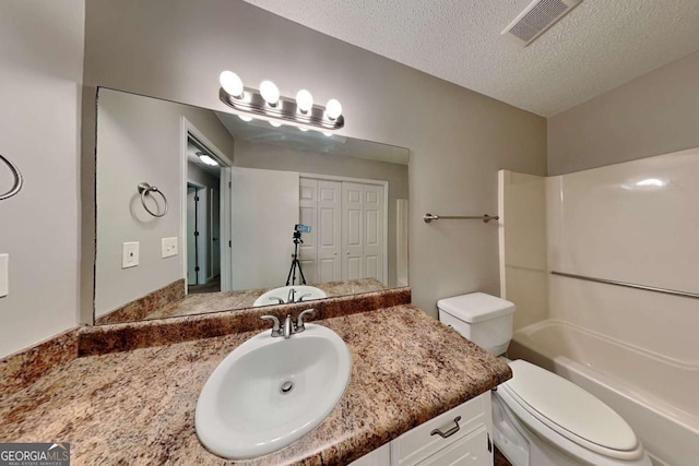 full bathroom featuring vanity, toilet, a textured ceiling, and shower / bath combination