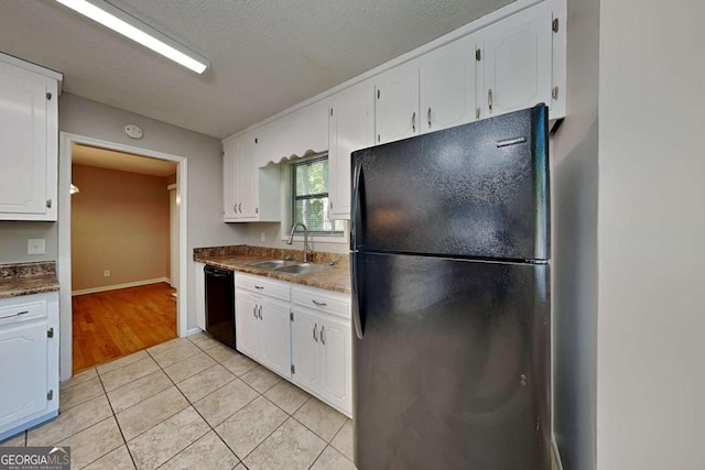 kitchen featuring sink, black appliances, a textured ceiling, light tile patterned floors, and white cabinets