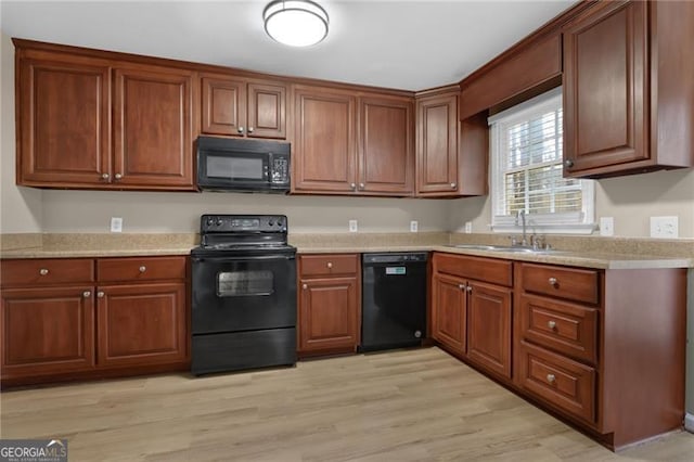 kitchen with sink, light wood-type flooring, and black appliances